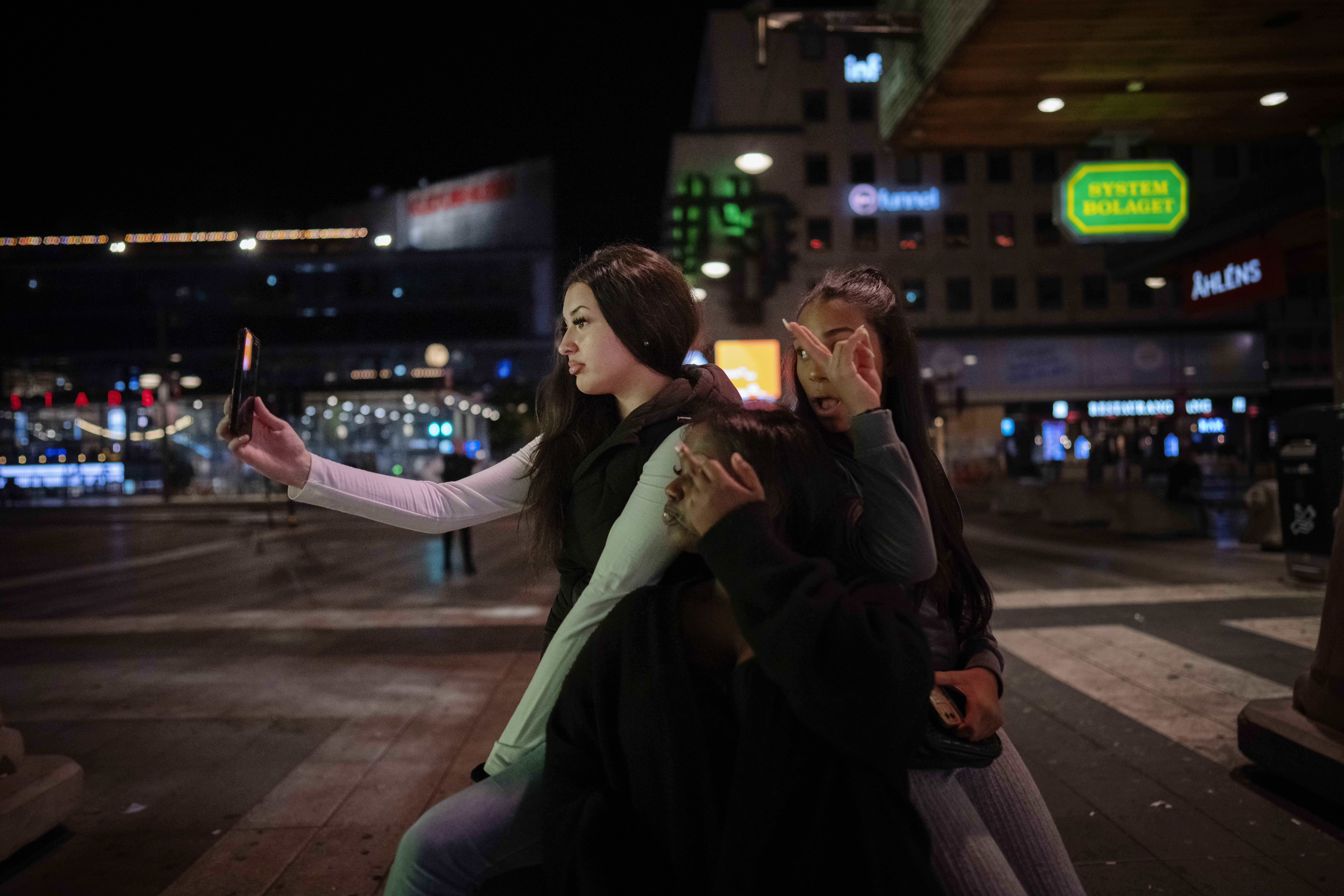 Denise och hennes två kompisar Oromiya och Marella sitter på en av de stora betong lejonen vid Sergels Torg, den 23 September 2023. De vet inte vad de ska göra, det är inget som händer och centrumet där de brukar vara är stängt. Men de tycker att det är skönare att vara i stan istället för hemma. Här kan dom röra sig fritt utan att bli tillsagda av gängmedlemmar vart dom får vara eller inte. Här får de vara i fred.